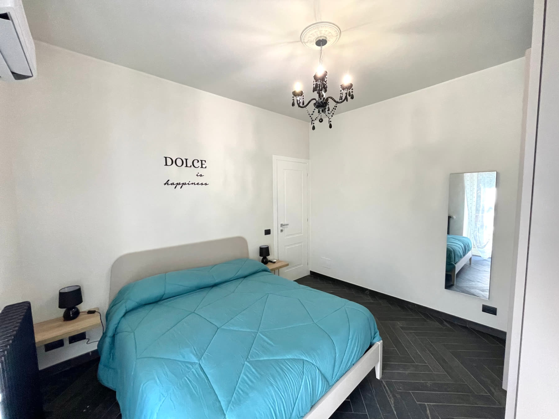 Second view of the bedroom with turquoise bedding and a Dolce is happiness wall decal