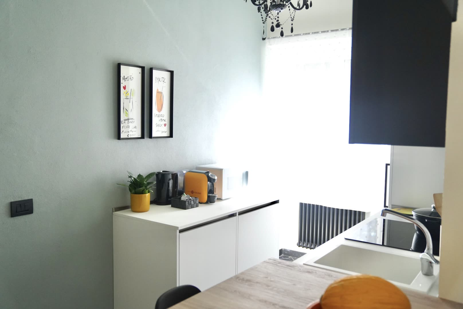 Coffee corner with orange espresso machine, kettle and mugs for guests at Dolce Apartments