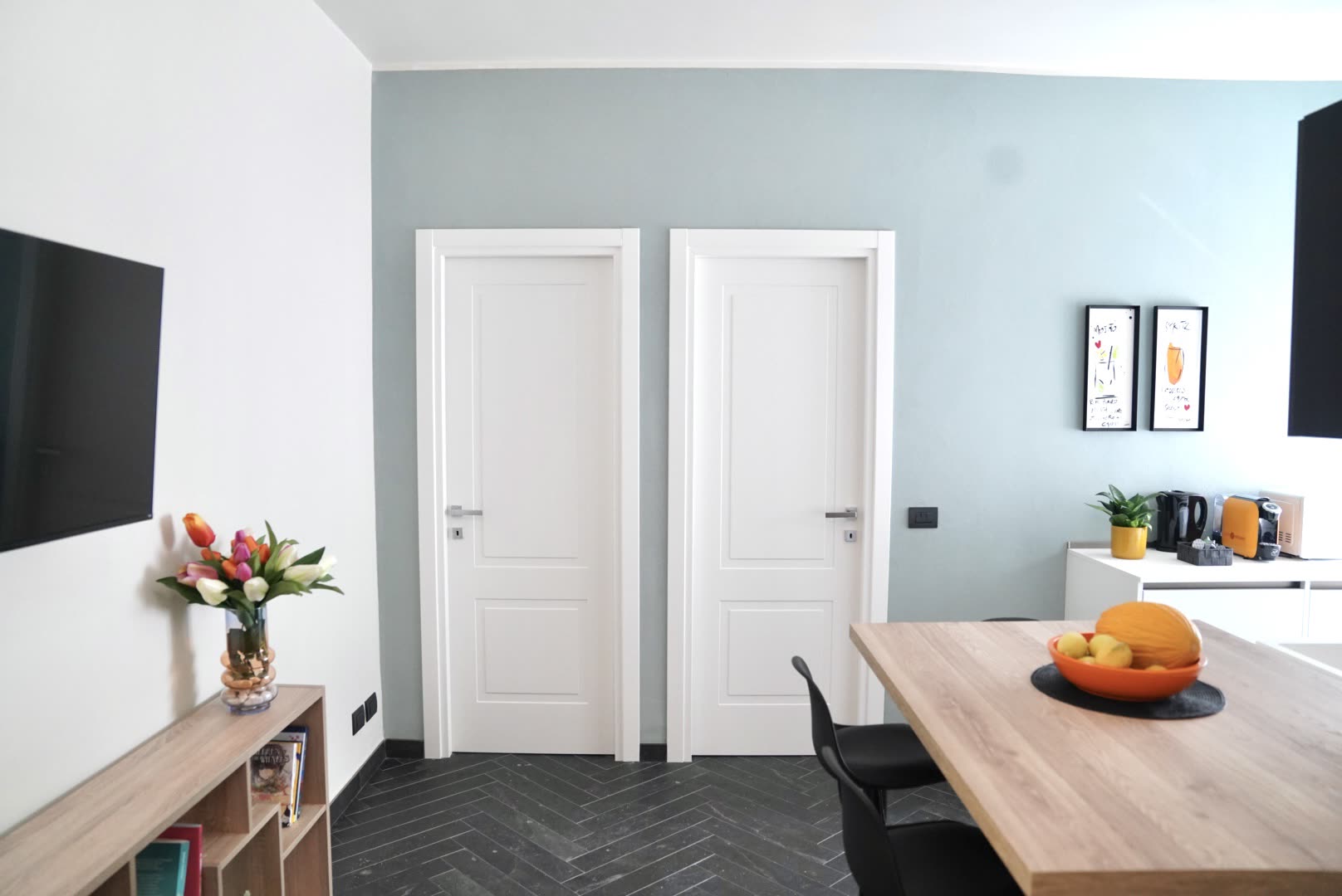 Bright interior of the holiday apartment with sage green accent wall and panelled doors