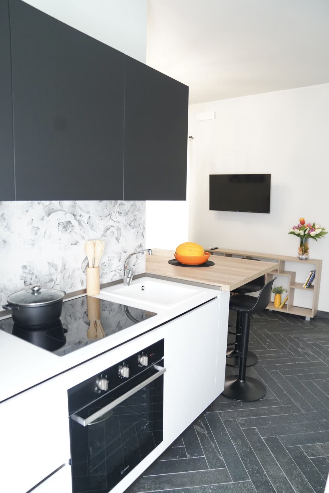 Fully equipped kitchenette with oven, induction hob and white cabinetry at Dolce Apartments
